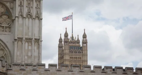 Westminster Palace Tower with British Flag Waving in London, UK Stock Footage 288097740