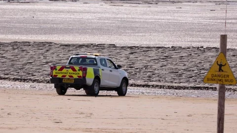 WESTON, UK - AUGUST 8, 2025 - Seafront ranger patrolling Weston super Mare beach Stock Footage 314804898