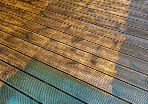 Wet and being cleaned old wooden brown terrace decking with the old paint Stockfoto's