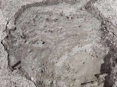 Wet cement mixture in ground pit on construction site Photos