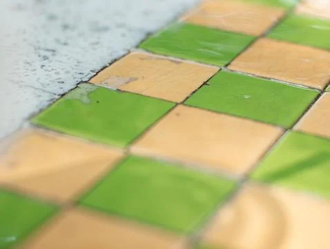 Wet Checkered Tile Floor with Shallow Focus and Blurred Bright Background Stock Photos