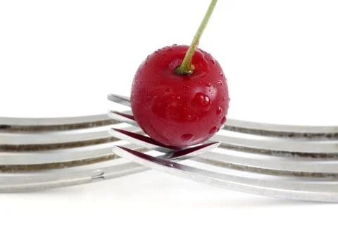 Wet cherry with two fork over white background Stock Photos