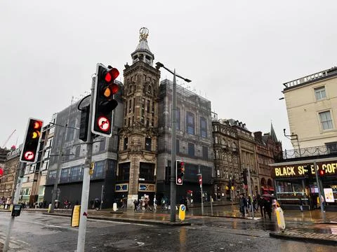 Wet city intersection with traffic lights and historic building in Edinburg.. Fotos de archivo