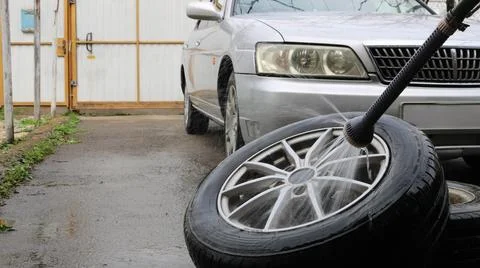 Wet cleaning of car wheels using a hose with a nozzle Stock Photos