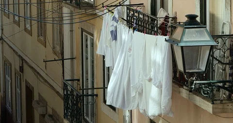 Wet clothes and linen sheets hanging out to dry on the facade of the building 4K Stock Footage 127152292