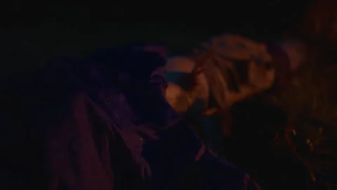 Wet clothes dry on a log next to campfire - night Видео 232343055