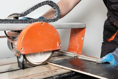 Wet cutting a ceramic tile. Stock Photos