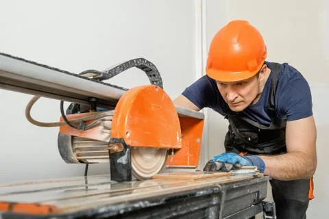 Wet cutting a ceramic tile. Stock Photos