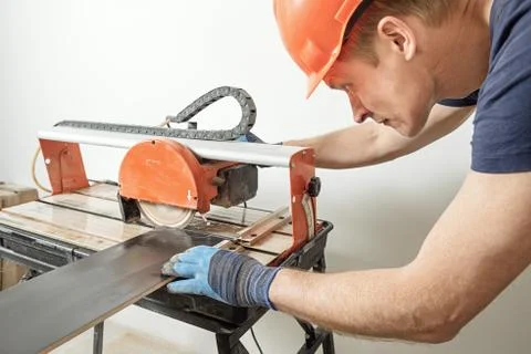 Wet cutting a ceramic tile. Stock Photos