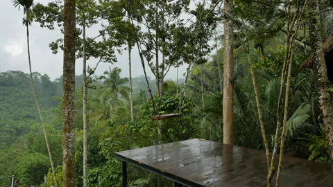 Wet empty tourist swing and beautiful view on jungles in the rain in Bali - 4K Stock Footage 194762665