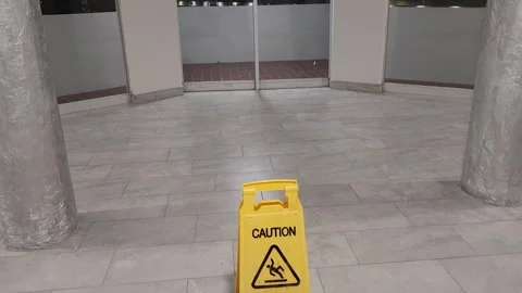 Wet floor warning signage inside modern tiled lobby Stock Footage 326418153