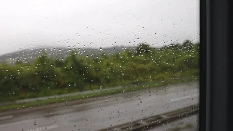 Wet glass from the rain of a moving bus. Video stock 302575131