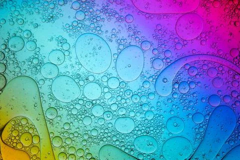 Wet gradient multicolored background with spilled oil as abstract pattern Stock Photos