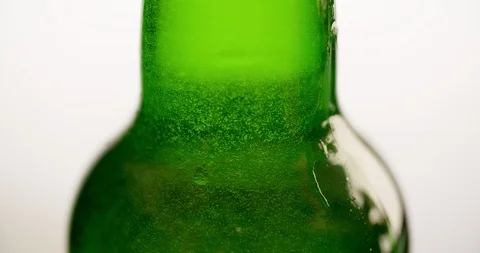 Wet Green Beer Bottle rotating with flowing droplet Closeup macro Slow motion Stock Footage 103640111