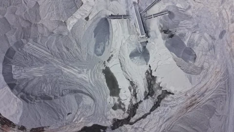 Wet ground shows patterns from water flow in a quarry during daytime 動画素材 339054906