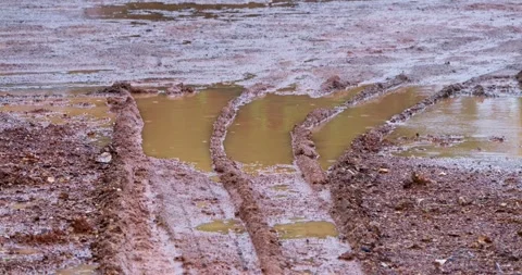 Wet landscape featuring mud puddles and tire tracks showcasing nature's beauty Stock Footage 345685806