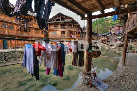Wet laundry drying on hangers under cover outdoors, Guizhou, China. Stock Photos