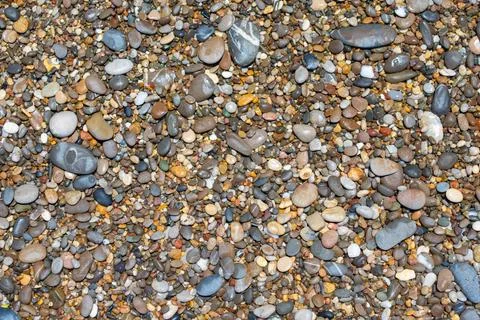 Wet multi-colored beach pebbles forming natural background texture Stock Photos