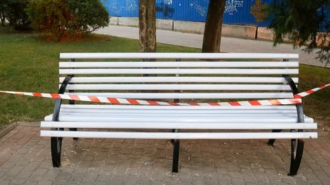Wet paint white bench with red and white fencing tape Stock Footage 113742857