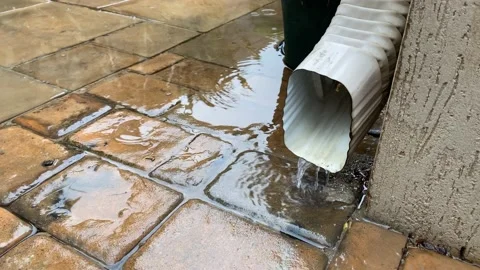 Wet pavement with rain water from a down flow gutter. Stock Footage 168489283