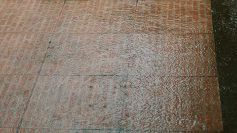 Wet pavement with raindrops creating ripples on red brick tiles. Stock Footage 282300271