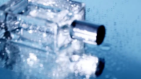 Wet perfume on blue rotating  camera Stock Footage 256651457