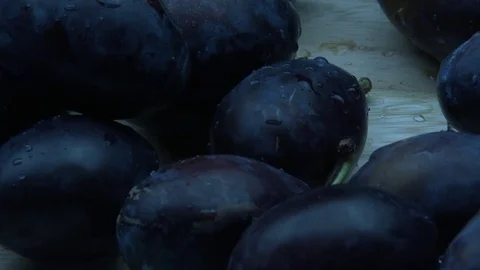 Wet plums fall on the desk 스톡 동영상 79915080