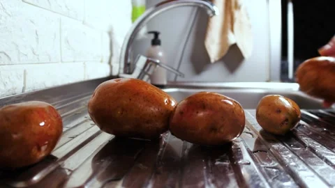 Wet potatoes rolling across the kitchen sink close up Video stock 263149065