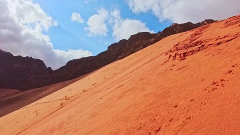 Wet red sand dune in Wadi rum with sandstone mountains dramatic sky and win.. Stock-Footage 330424765