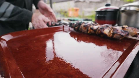 Wet Red Serving Tray Reflecting Trees with Blurred Grilling in Background Video stock 333822726