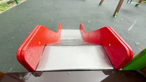 Wet Red Slide Collects Raindrops in Empty Outdoor Playground Stock Footage 336093675