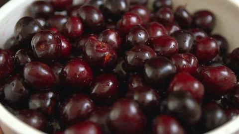 Wet ripe red cherries falling into a colander Stock Footage 94053696