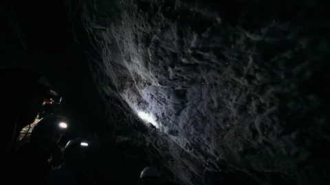 A wet rocky cave. People explore a walls of the cave covered with minerals Stock Footage 108315067