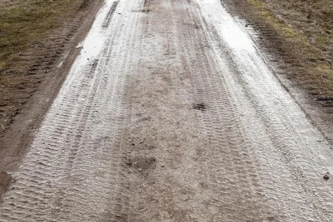 Wet rural road perspective with tire tracks Stock Photos