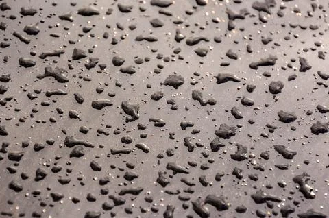 A wet surface with many small drops of water scattered across it Stock Photos