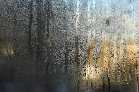 Wet window forms textured pattern on transparent glass. 库存照片