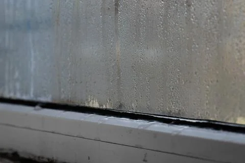 Wet window glass with condensation droplets forming abstract texture, close.. Foto stock