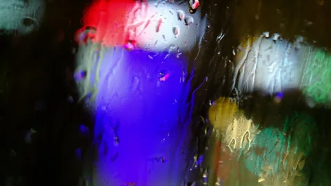 Wet window inside in car, defocused traffic jam,rainy night Stock Footage 310723652