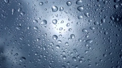 Wet windshield taken from the interior of a car. Rain falls on the surface of a Stock Footage 152530989