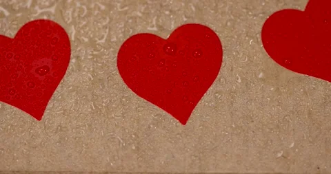 Wet yellow cardboard for packaging goods and products with red plastic hearts Stock Footage 324690502