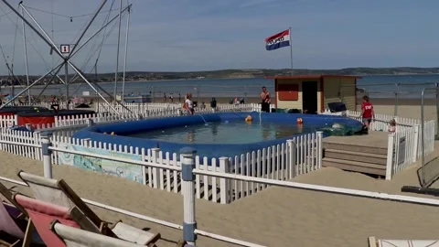 Weymouth beach pool and fun fair rides looking to sea Stock-Footage 137268682