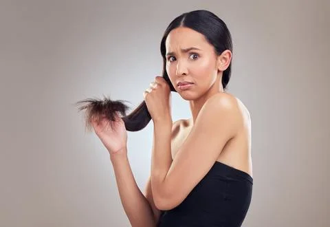 What am I going to do about these split ends. an attractive young woman holding Stock Photos