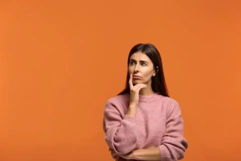 What are they doing. why. Pensive woman in pink sweater, holds finger and nea Stock Photos