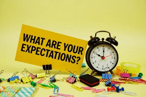 What Are Your Expectations? text on paper card with alarm clock and station.. Stock Photos