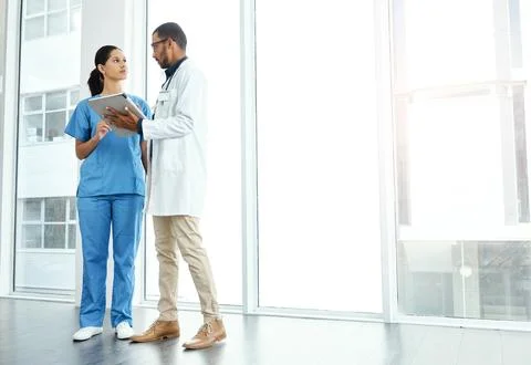 What are your thoughts on this. two young doctors using a digital tablet in a Stock Photos
