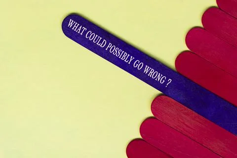 What could possibly go wrong question text on purple color wooden stick. Stock Photos