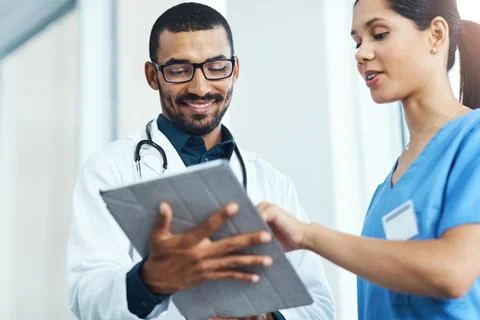 What do the lab tests say. two young doctors using a digital tablet in a modern Stock Photos