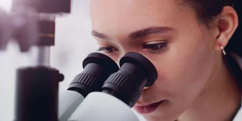 What do we have here. a young scientist using a microscope in a lab. Stock Photos