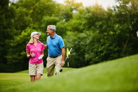 What do you think of this golf course. a mature couple on a golf course. Fotos Stock
