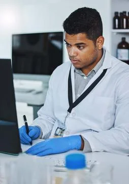 What does the data say. a young male researcher using a computer while taking Foto stock